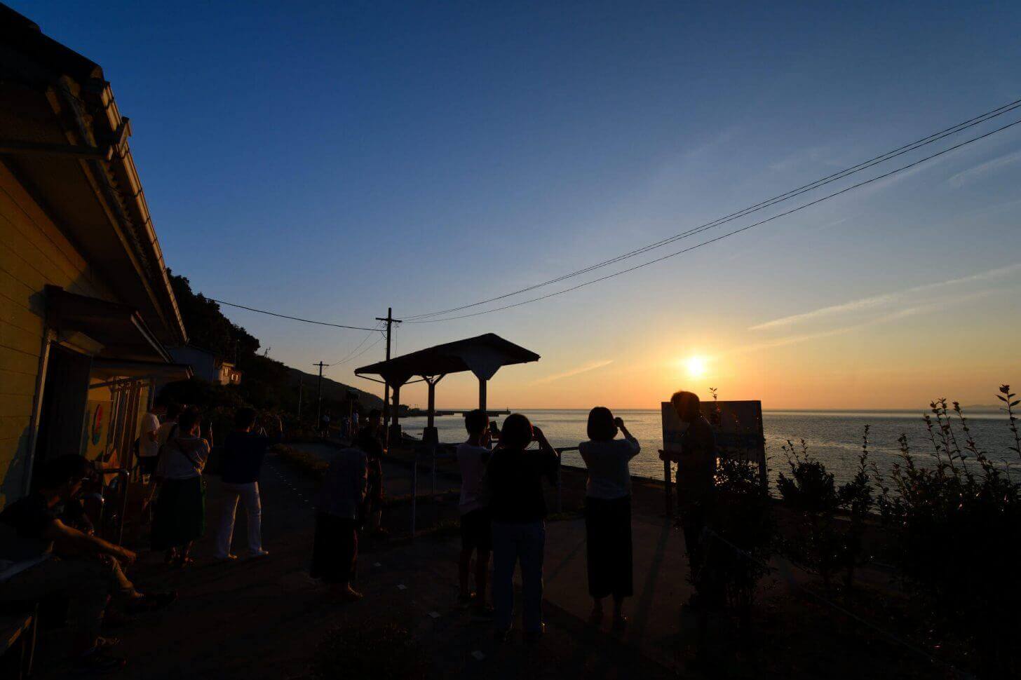 たくさんの人が見守る下灘駅の夕日